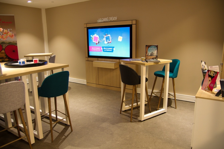 Le Carré Créatif Carrefour Voyages — espace autonome avec tabourets turquoise pour composer son voyage